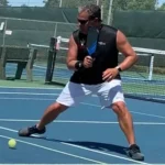 Man playing pickleball on outdoor court.